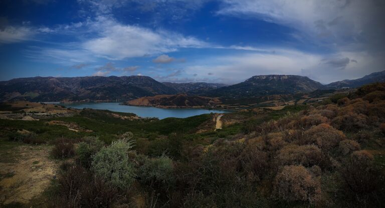 nice view, mountain with trees and flowers all around with a small lake in the middle of them, this can be seen from natural park of drymos